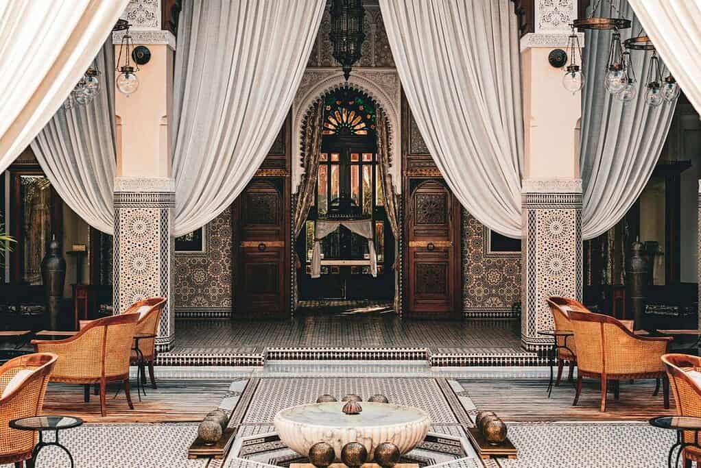 Cour intérieure d'un riad de Marrakech, zellige, fauteuils et tables basses