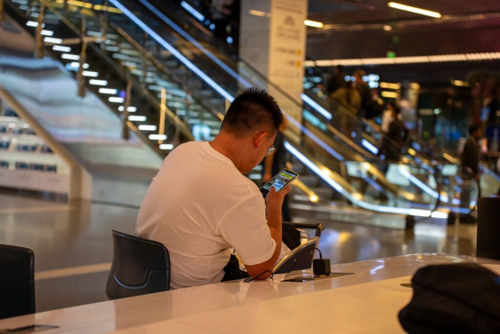 Voyageur consultant son téléphone dans un terminal d’aéroport