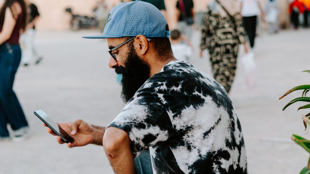 Voyageur consultant son smartphone dans une rue de Rabat, au Maroc